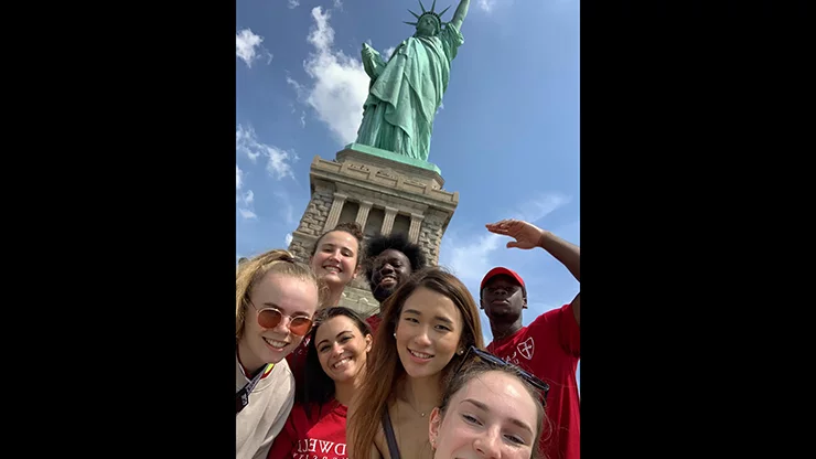 Caldwell University international students group photo outside statue of liberty.