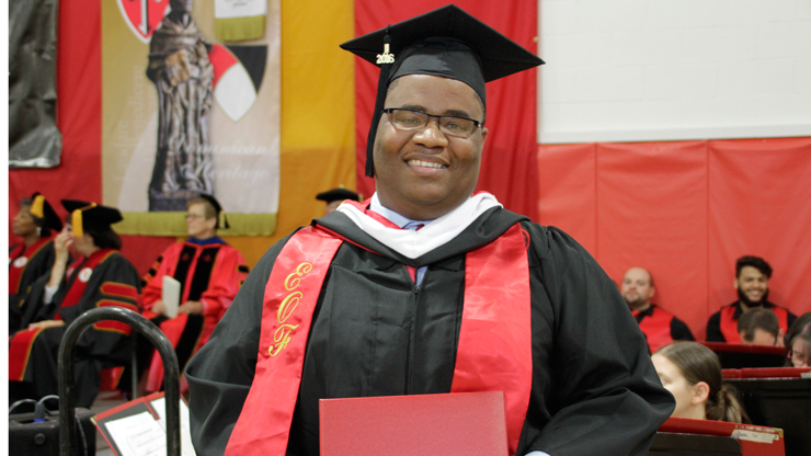 Caldwell Student holding his Degree Certificate after Commencement