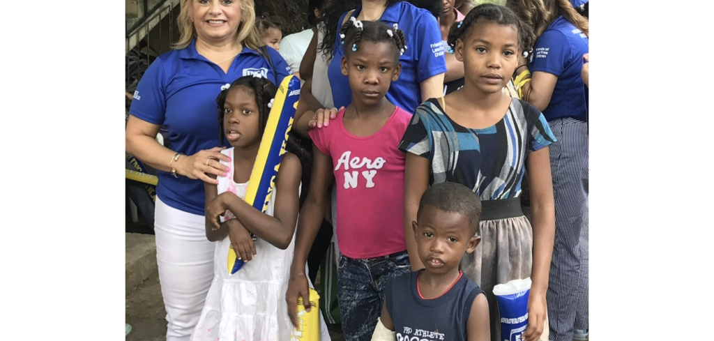 Liz Berman ’84, far left, and mission trip volunteers with local children in the Dominican Republic.